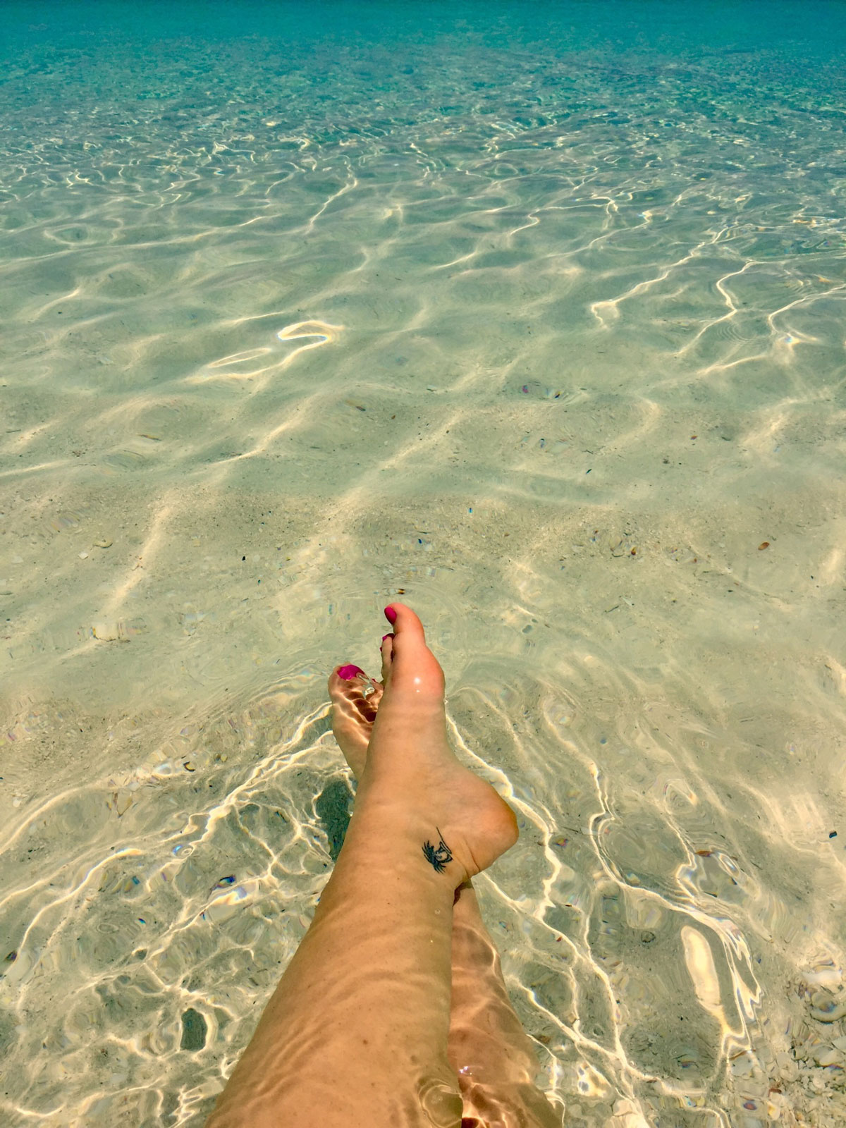 Picture of Taryn's feet in the beautiful clear water of Grace Bay.